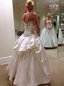 a woman in a wedding dress looking at herself in the mirror