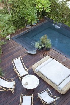 an outdoor pool with chairs and tables around it