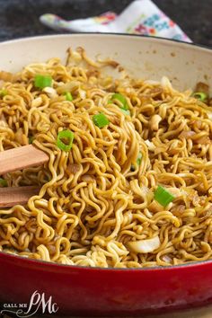 a red pan filled with noodles and vegetables