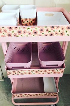 a pink cart with two bins on top of it and some baskets in the bottom