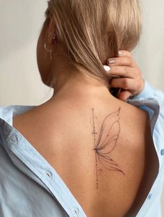 the back of a woman's shoulder with a small tattoo on her left side