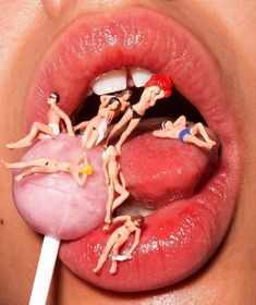 a woman's tongue with toy figures on top of it and a stick sticking out of her mouth