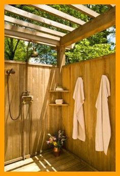 a wooden shower with two white towels hanging on the wall