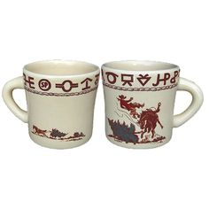 two cups with designs on them sitting next to each other