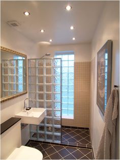 a bathroom with a toilet, sink and shower stall in the middle of it's tiled floor