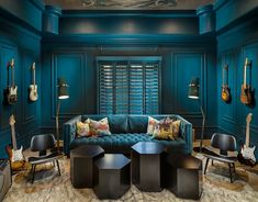 a living room with blue walls and guitars on the wall