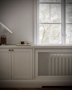 a kitchen with white cabinets and an air conditioner on the counter next to it