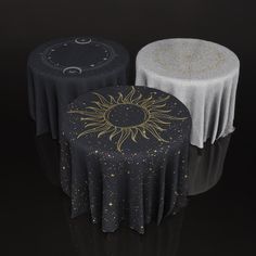 two black and white round tables with gold designs on the tablecloths are shown