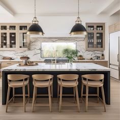 a kitchen with marble counter tops and wooden chairs