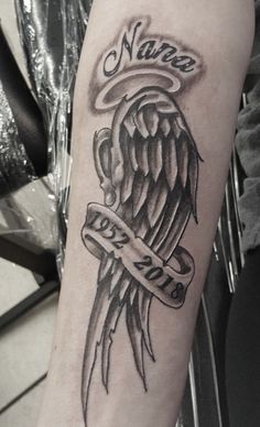 a black and white tattoo with an angel holding a banner on it's arm