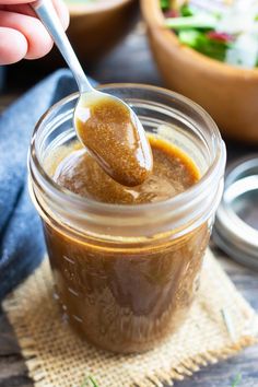 a spoon full of peanut butter on top of a jar