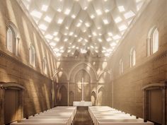 an empty church with rows of pews lined up in front of the alter, and sunlight streaming through the windows