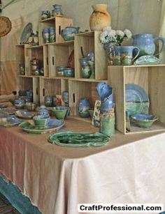 a table with plates and vases on it in front of a tented area