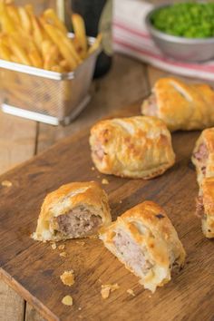 meat and cheese pastries on a cutting board with french fries in the back ground