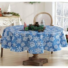 a blue table cloth with white snowflakes on it and christmas trees in the background