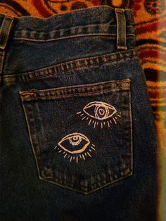 the back pocket of a pair of jeans with an eye drawn on it