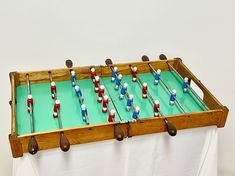 an old foosball table with wooden handles and blue, white and red pins