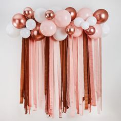 a bunch of balloons with tassels hanging from it