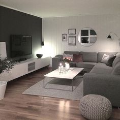 a living room filled with furniture and a flat screen tv on top of a wooden floor