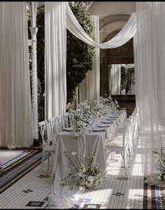 the tables are covered with white cloths and flowers