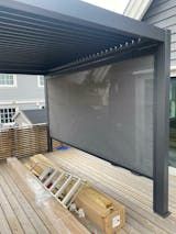 a large screen on the back deck of a house with an awning over it