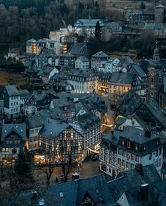 an aerial view of a city at night with lots of buildings and lights in the foreground