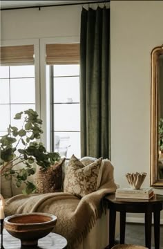 a living room filled with furniture and a large mirror on the wall next to it