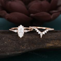 two engagement rings sitting on top of a piece of wood