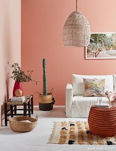 a living room with pink walls and white furniture