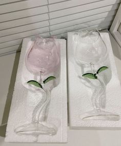 two glass vases sitting on top of towels