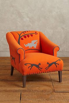 an orange chair sitting on top of a wooden floor