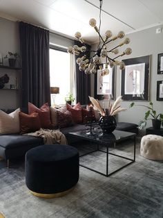 a living room filled with furniture and a chandelier hanging over the top of it