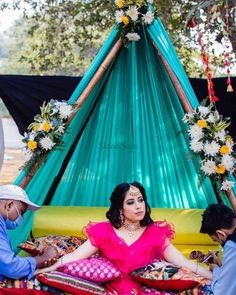 a woman sitting on top of a bed under a canopy