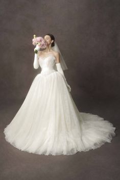 a woman in a wedding dress holding flowers