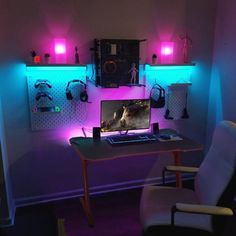 a desk with a computer on it in a room lit up by purple and blue lights