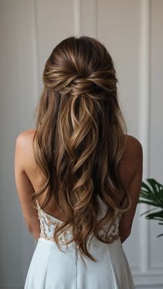 the back of a woman's head with long, wavy hair in her wedding dress