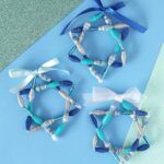 three pieces of blue and white paper with bows on them sitting next to each other