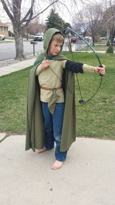 a young boy dressed up as the lord of the rings with an arrow and bow