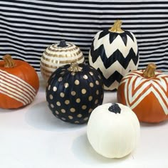 pumpkins painted with black and white stripes, gold polka dots and striped pumpkins