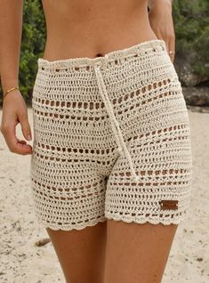 a close up of a person wearing crochet shorts