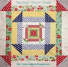 a close up of a quilt with the words nested churn dash on it