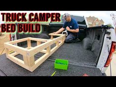 a man sitting in the back of a truck with a bed frame attached to it