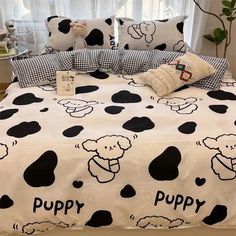 a bed covered in black and white polka dots with a dog on it's cover