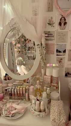 a vanity with lots of items on it and a large round mirror in the corner