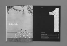 an open magazine with a bicycle and t - shirt on the front, next to a tree