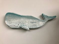 a ceramic whale is sitting on the wall