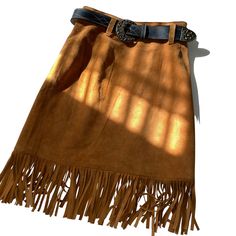 This 80s Cedars leather skirt features a western style with fringes and a belt. The soft leather material makes it comfortable to wear and the brown color gives it a classic look. The skirt is in great shape and has been well-maintained over the years. The skirt is a size 6 and fits true to size. The Cedars brand is known for their quality leather products and this skirt is no exception. Perfect for a vintage or western-inspired look, this skirt is a must-have for any fashion-forward individual. Western Style Brown Bottoms For Fall, Fall Brown Belted Skirt, Brown Fringe Mini Skirt, Leather Products, Winter Sale, Western Style, Belt Size, Leather Material, Classic Looks