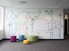 an empty room with colorful stools and painted wall