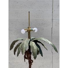 a lamp that is on top of a pole with a plant in front of it