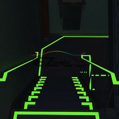 stairs lit up with neon green lights in a dark room, leading to a stairwell